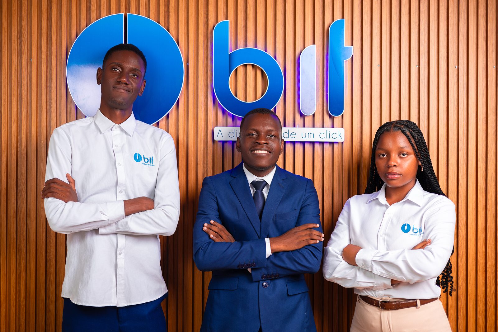 The BIT team in front of the logo, at the office